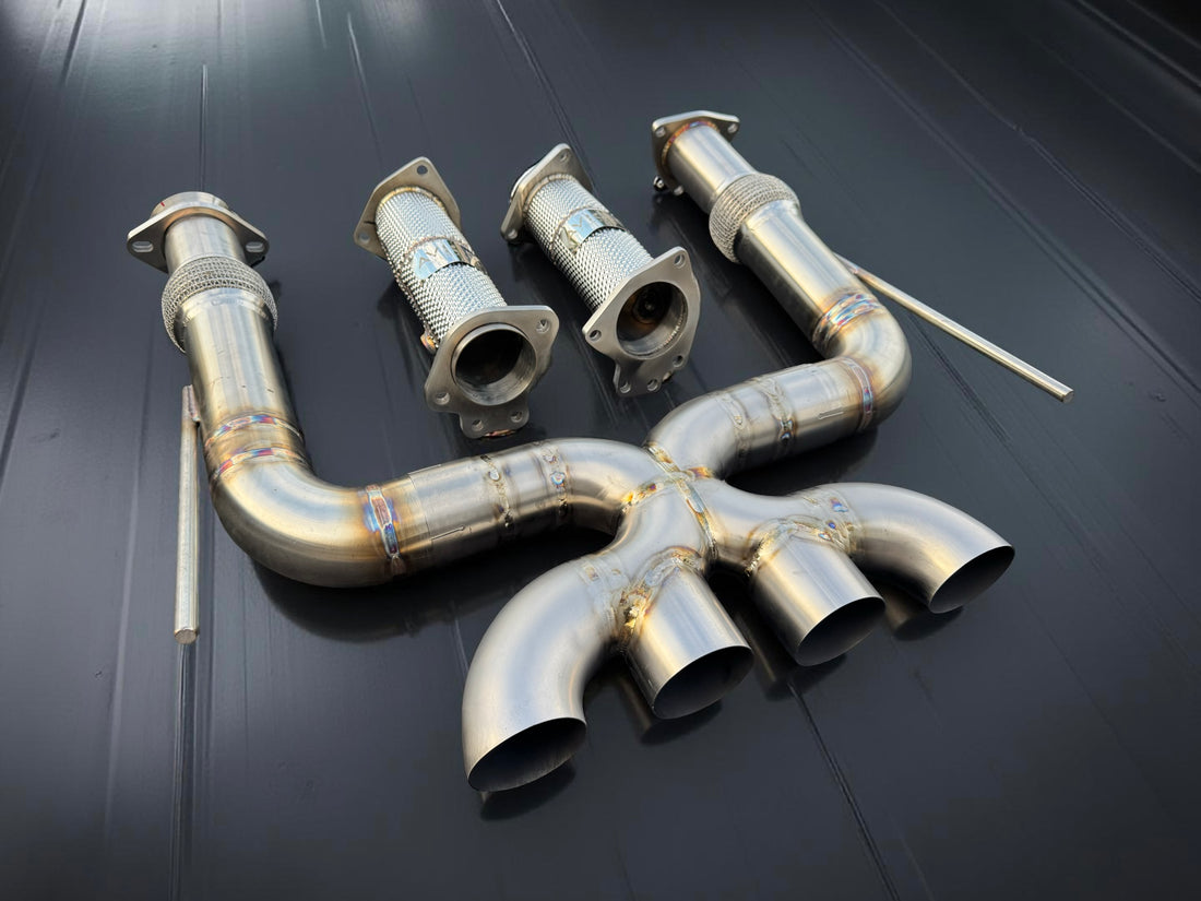 Set of metallic exhaust pipes on a dark background